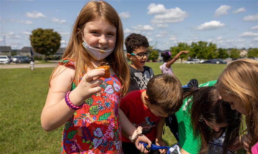 Students smile while releasing butterflies outside